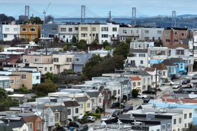 In an aerial view, homes stand in front of the Oakland-San Francisco Bay Bridge on June 09, 2023 in San Francisco, California.