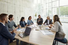 A group of business people sitting around a table.