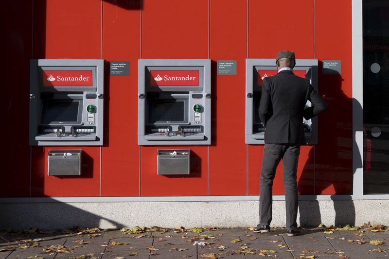 A man uses a Santander cashpoint