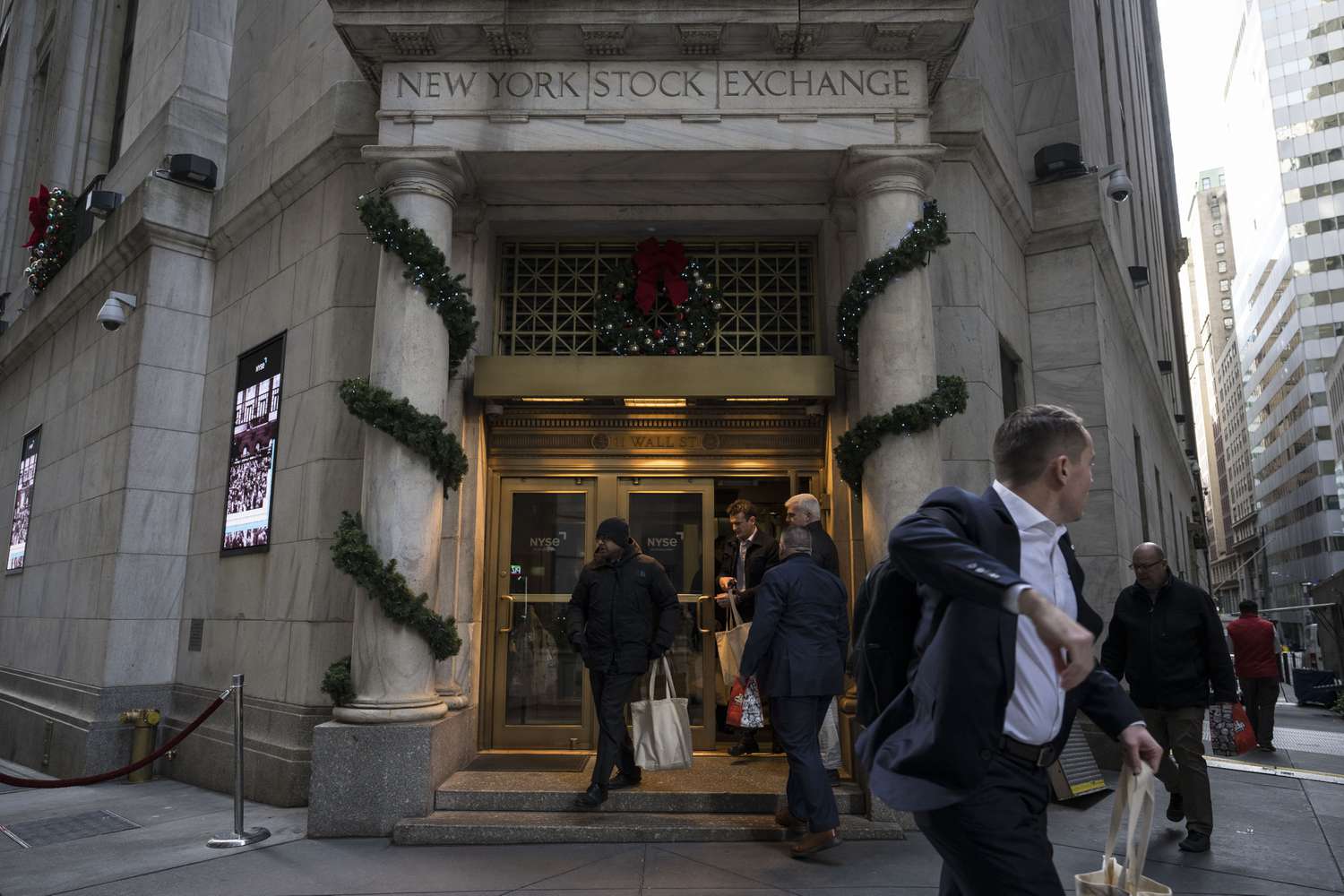 People walk in and out of the New York Stock Exchange (NYSE).