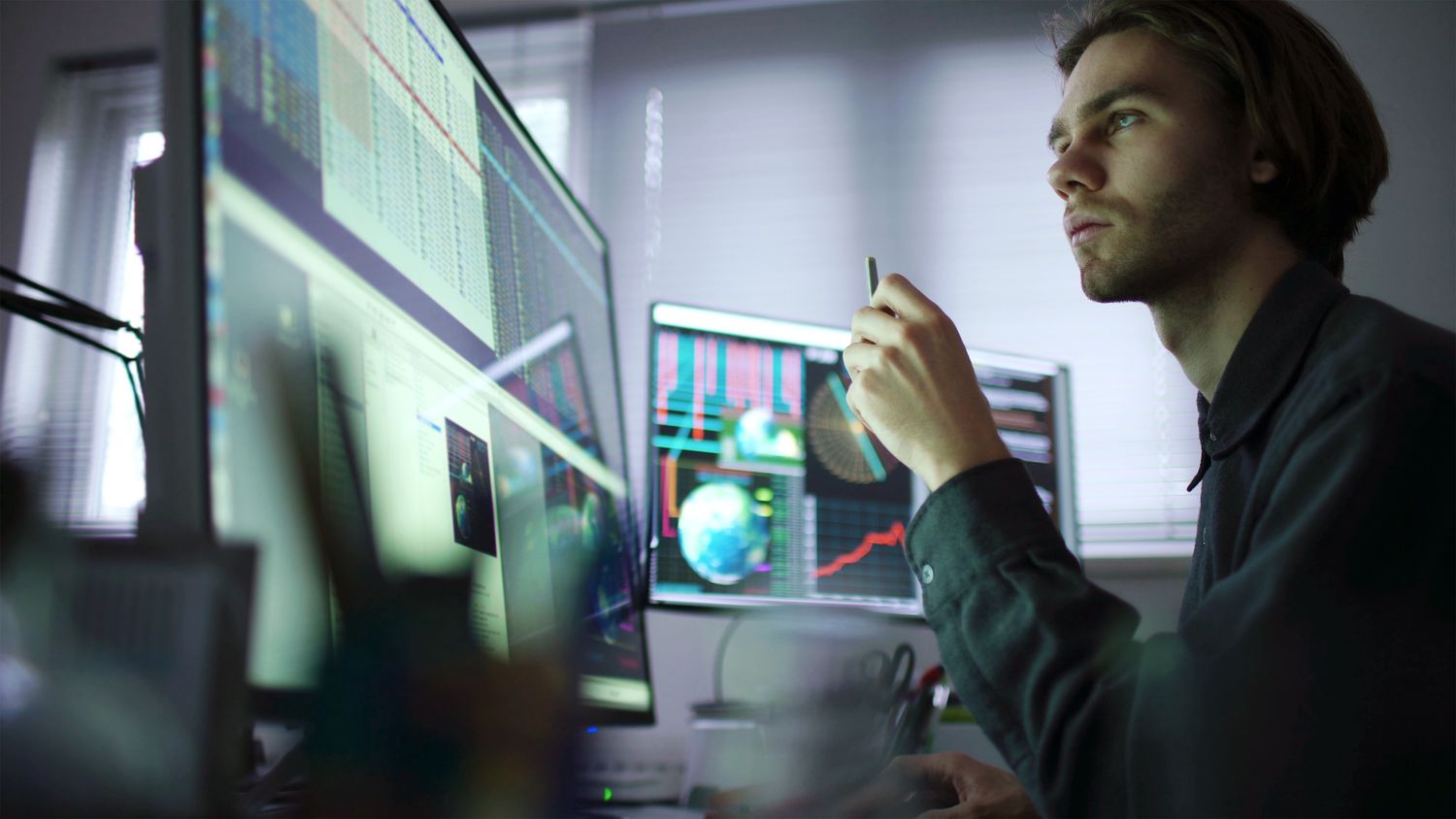 A stock investor sitting at their computer looking at their long position stock trades.