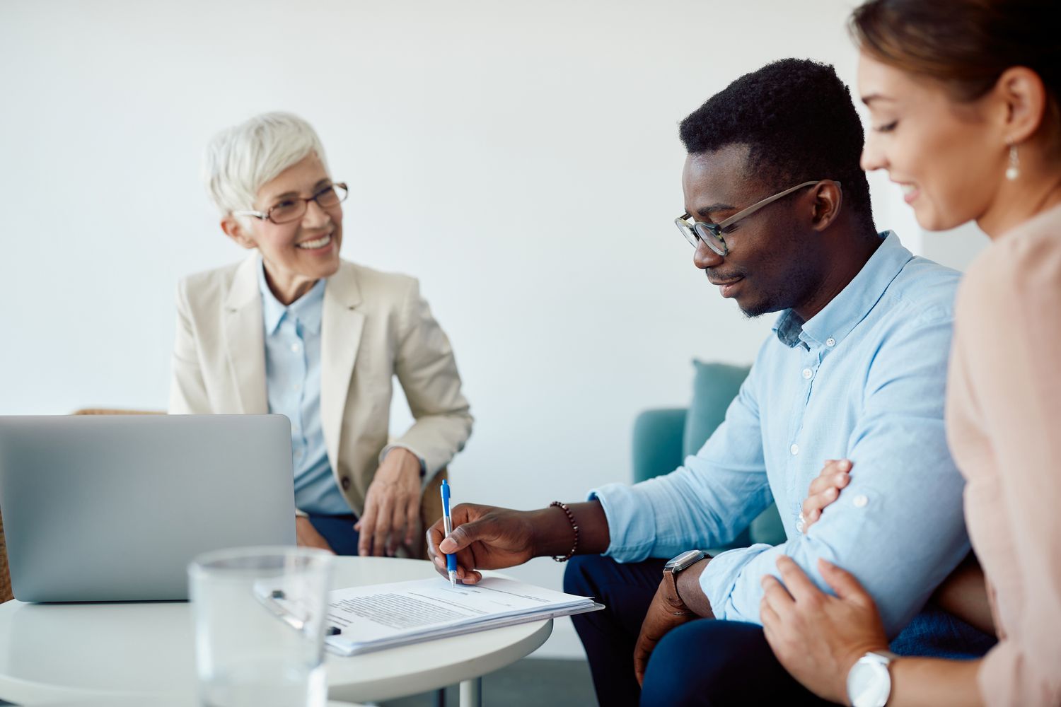 A couple signs a contract with a mortgage banker.