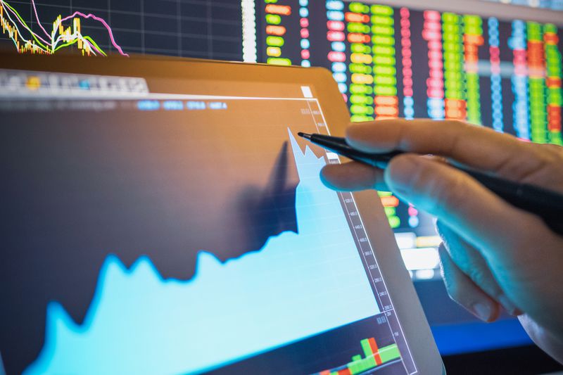 Hand pointing to tablet with financial information
