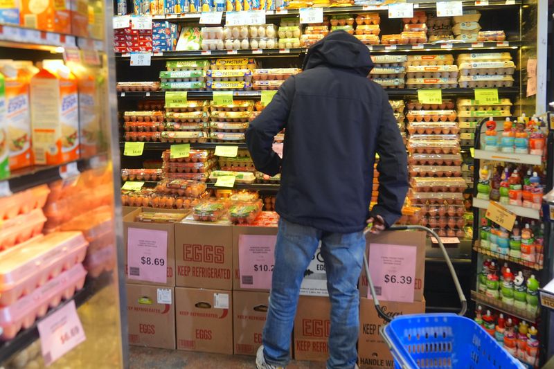 A customer is seen during shopping at a supermarket as packages of eggs are seen on the shelves of the egg aisle in New York City