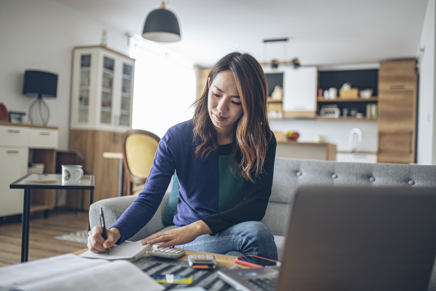A young woman doing her finances at home.