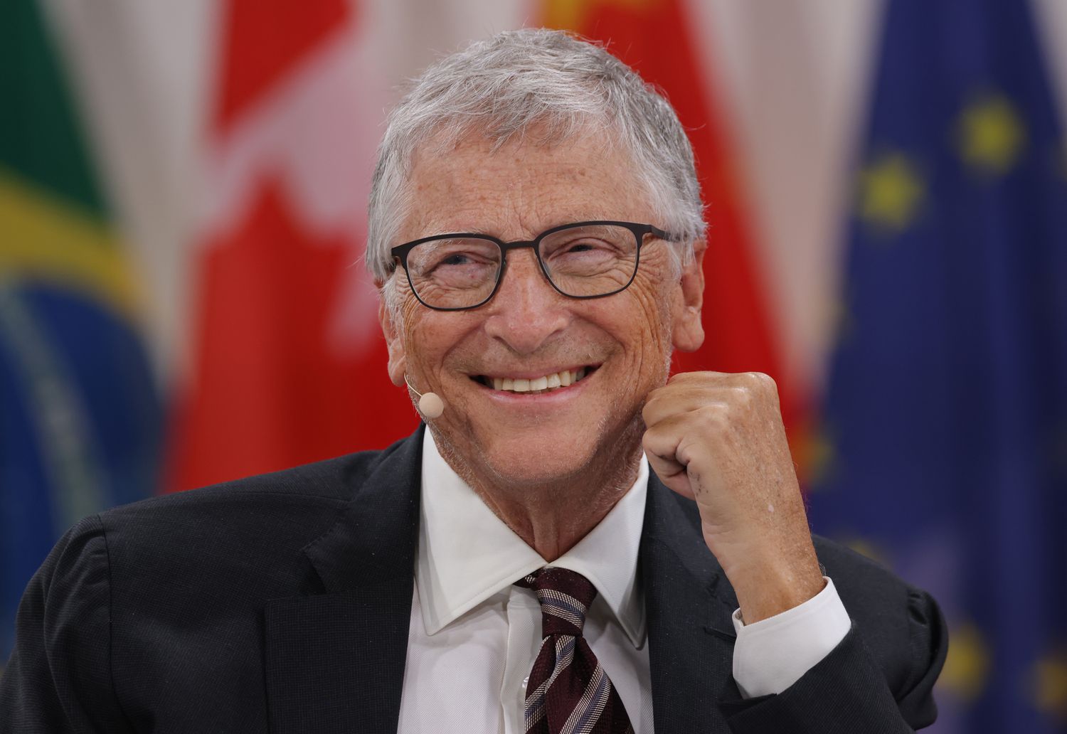 Bill Gates smiling while on a panel.
