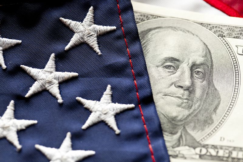 Close-up of U.S. flag and $100 U.S. bill