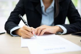 Business Woman Signing Documents