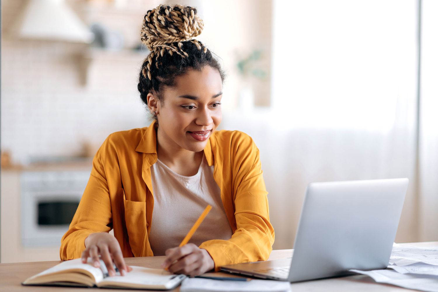 A woman sits at a desk with a laptop. 
