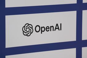 The black OpenAI logo is seen on a white and blue background.