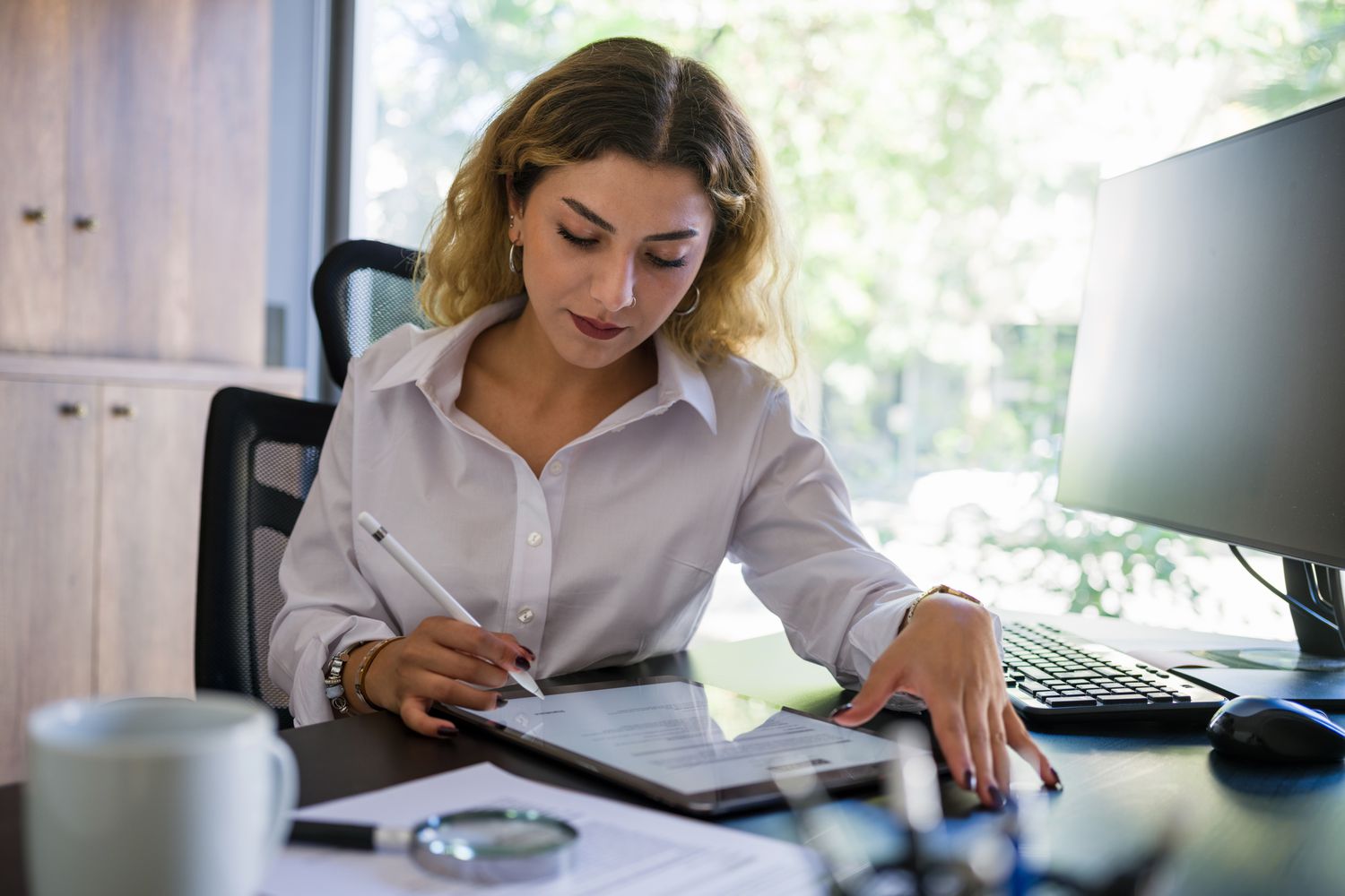 Business person at desk, signing title document.