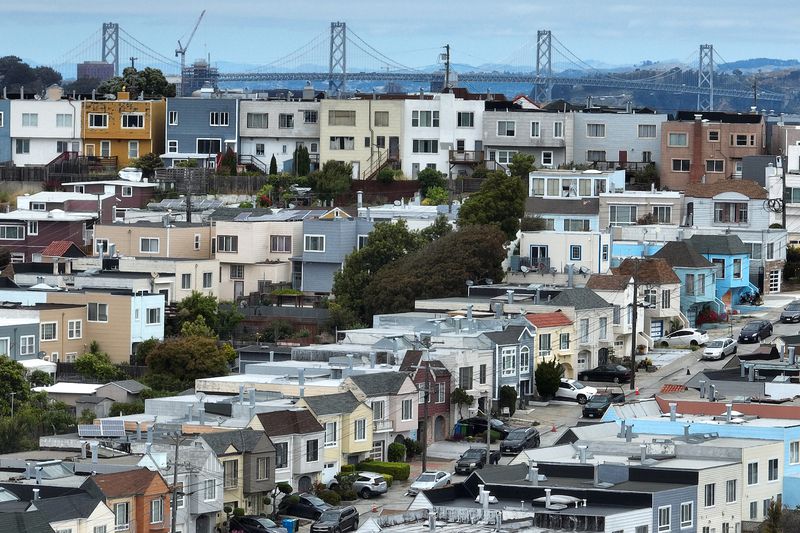 In an aerial view, homes stand in front of the Oakland-San Francisco Bay Bridge on June 09, 2023 in San Francisco, California.