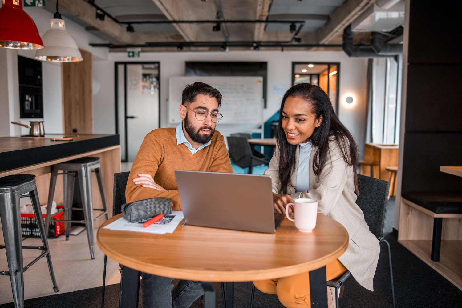 A couple sitting in a cafe with laptop open to look up information about Zero-Dividend Preferred Stock.