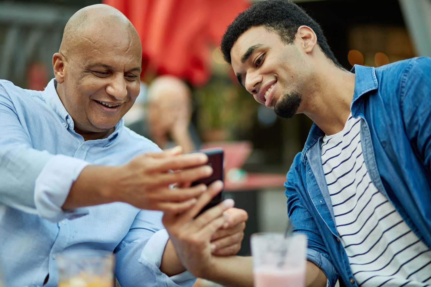father son looking at a smartphone