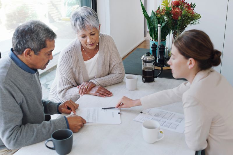 A couple reviews paperwork with an executive.