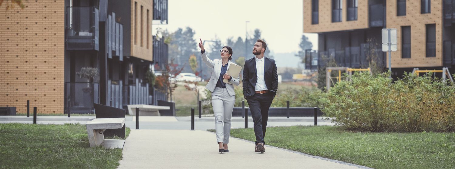 Real estate agent pointing out a building to a client