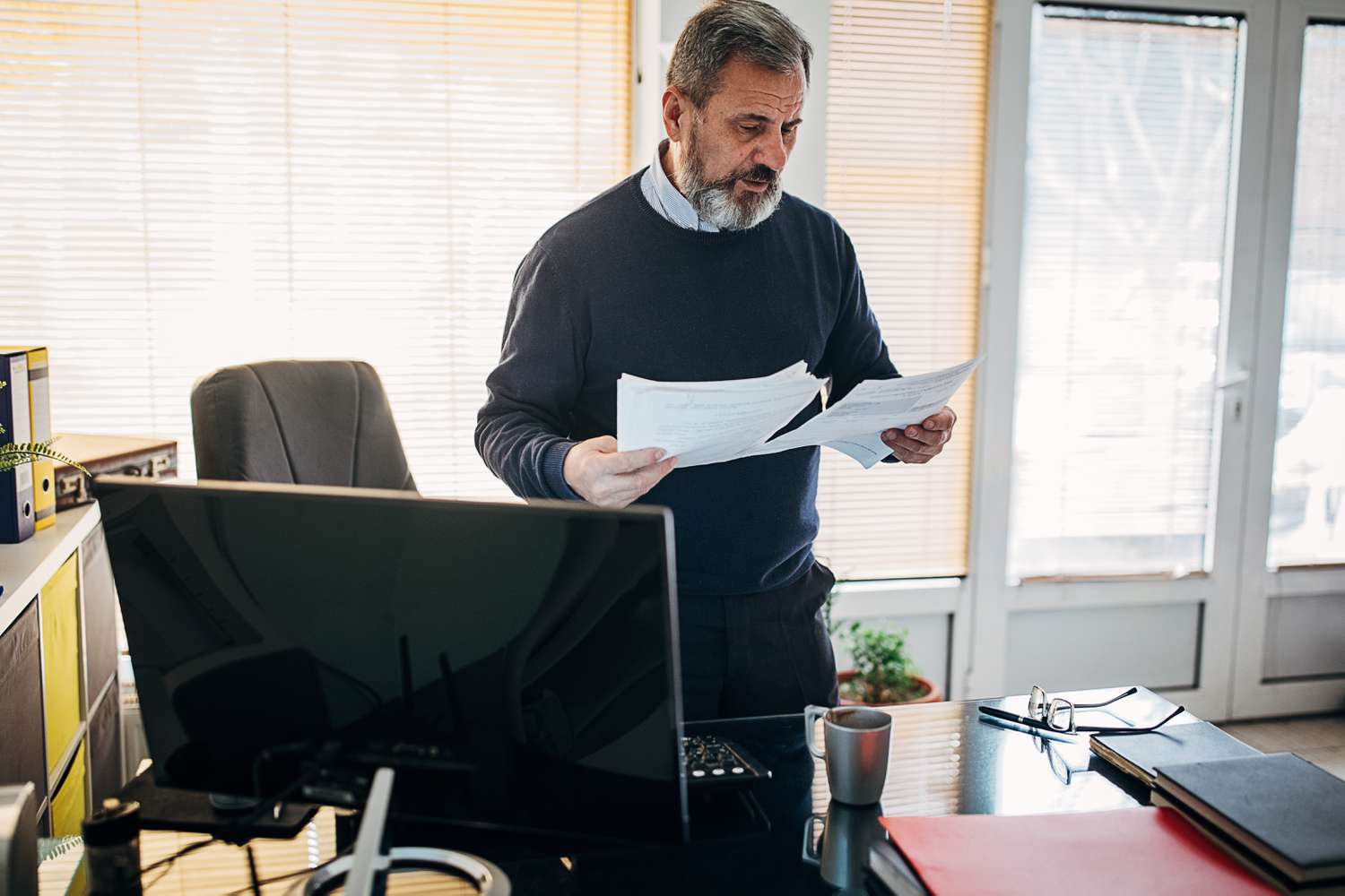 A man who lost his spouse is looking over papers about his reverse mortgage
