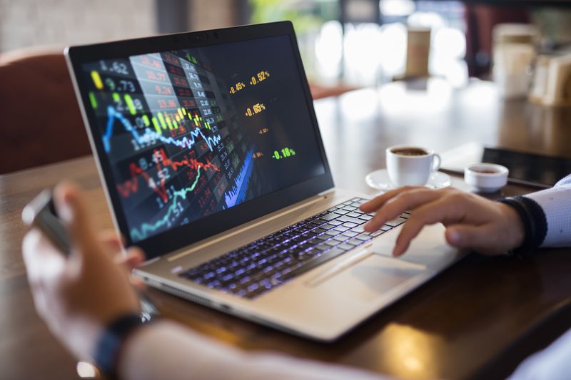 Investor uses laptop to analyze stock market data.
