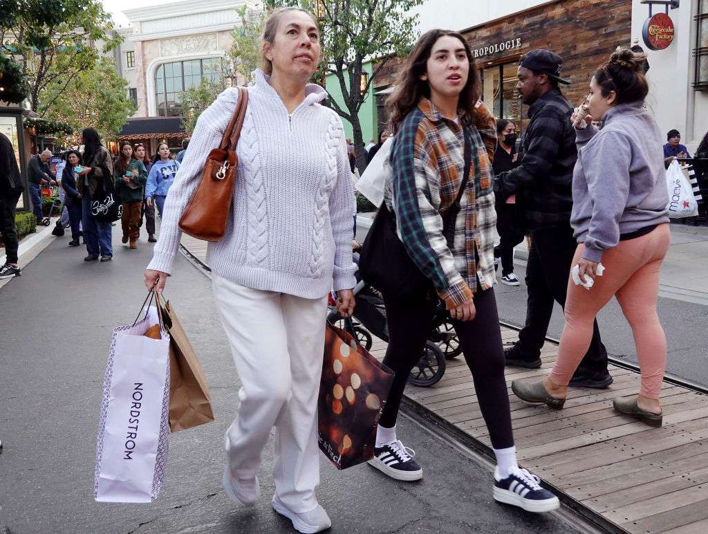 A person carries shopping bags in the Americana at Brand shopping center on the day after Christmas on December 26, 2023 in Glendale, California.