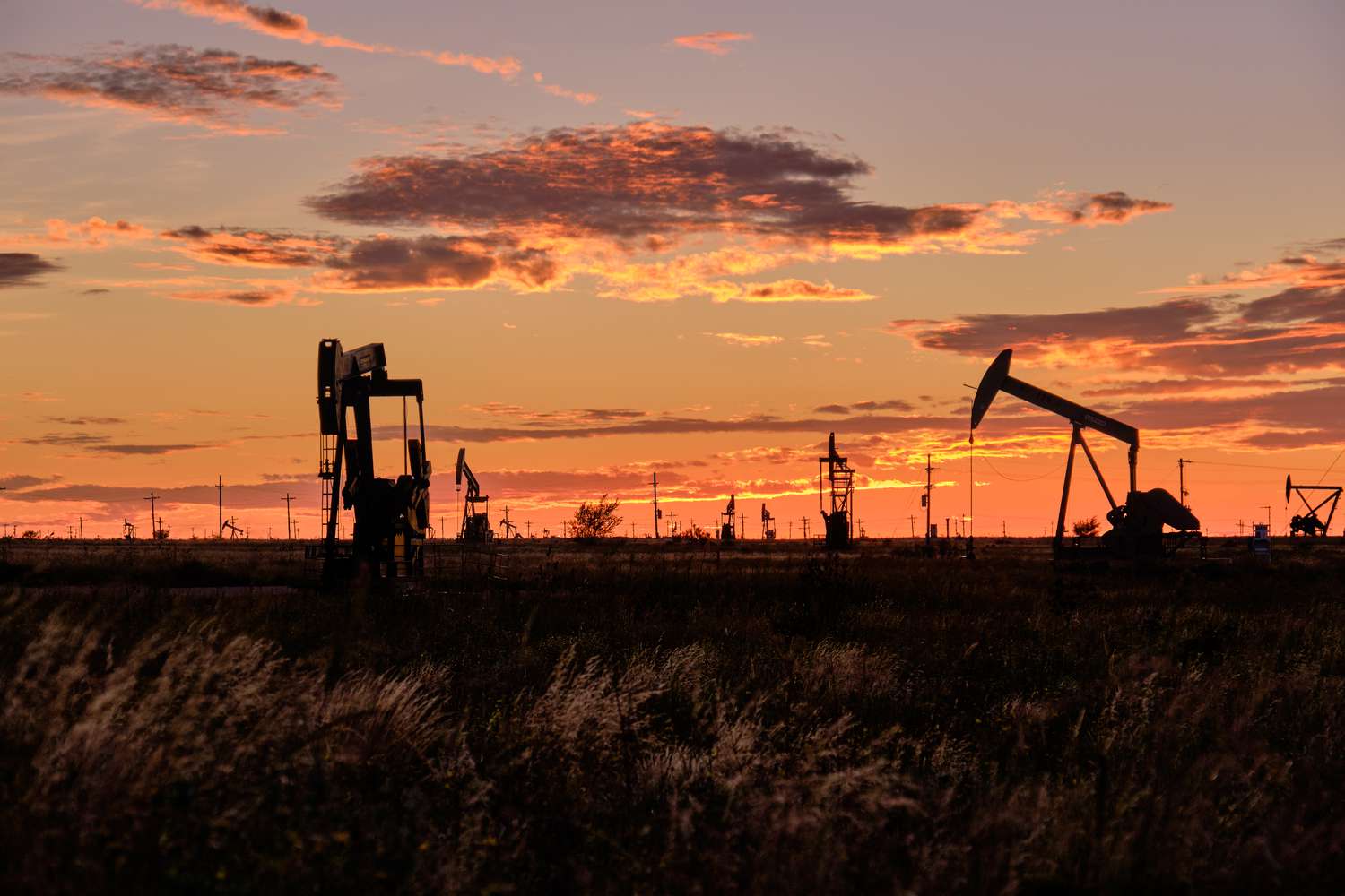 Sunset silhouetted shale oil pumpjacks in Midland, Texas