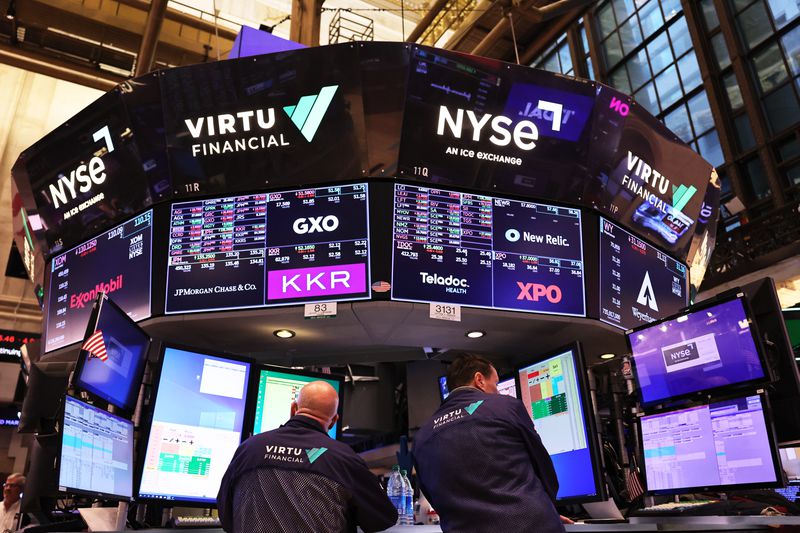 Two traders work beneath large computer screens at the New York Stock Exchange