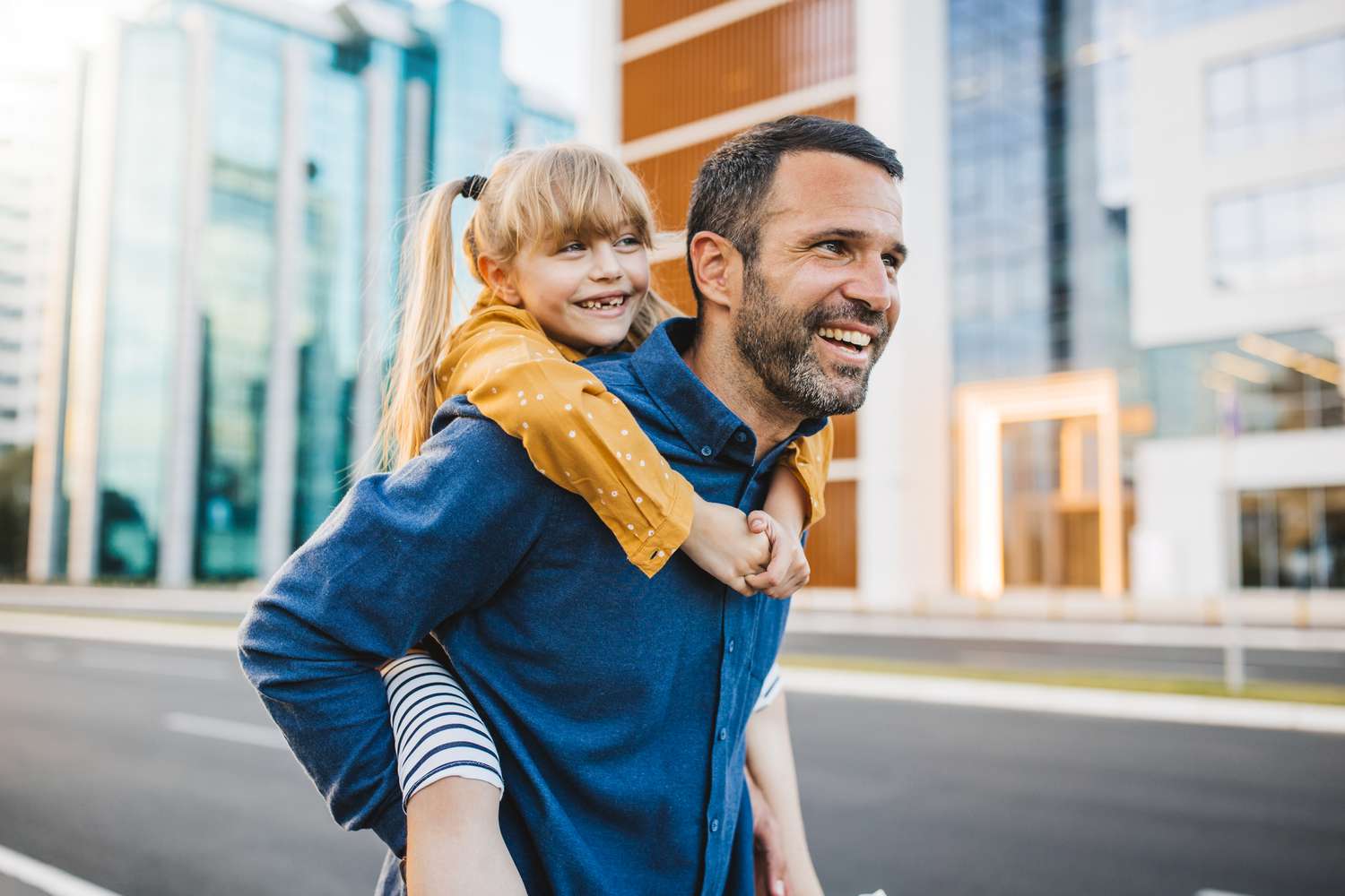 Father and daughter walking outside in a city