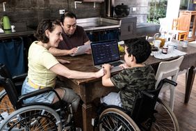 A family doing research together in their kitchen about the best companies for long-term disability insurance.
