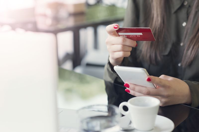 woman holding credit card and cellphone