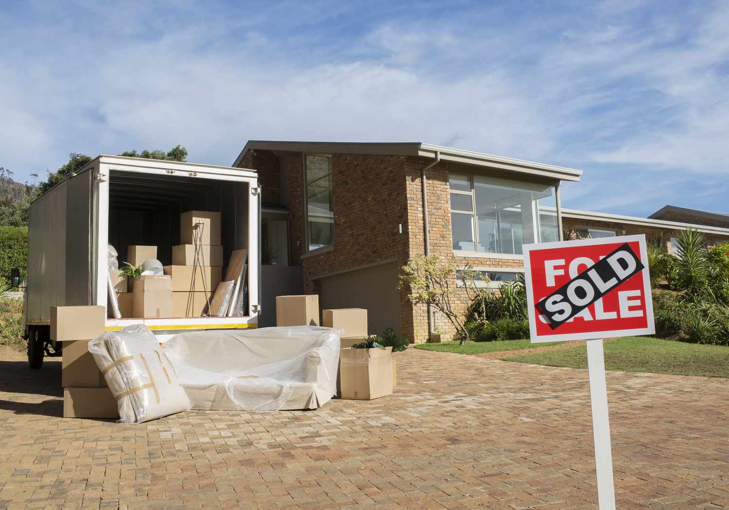 Sold sign and moving van outside house