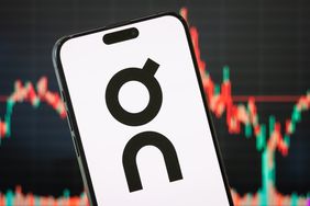 The logo for On Holding is seen on a smartphone screen, with a stock chart in the background.