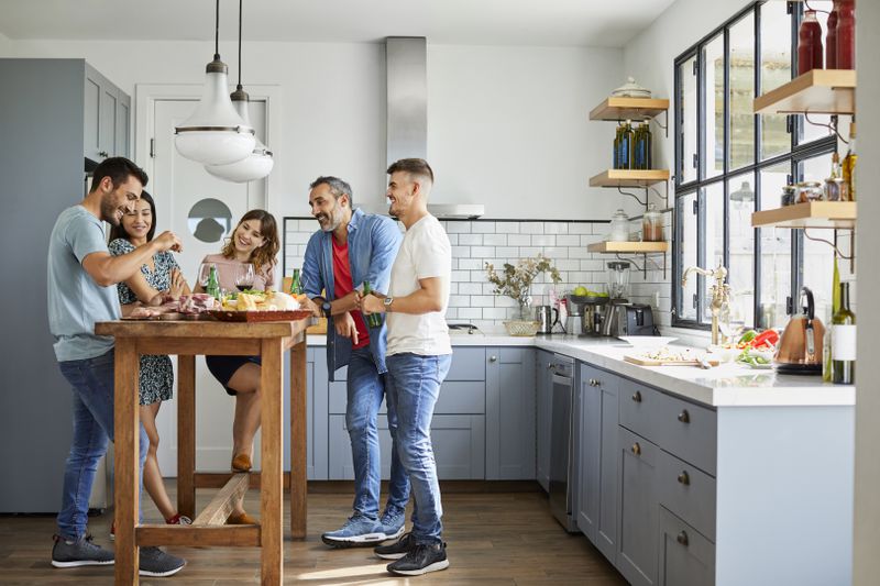 Friends enjoying a meal in the kitchen of a home.