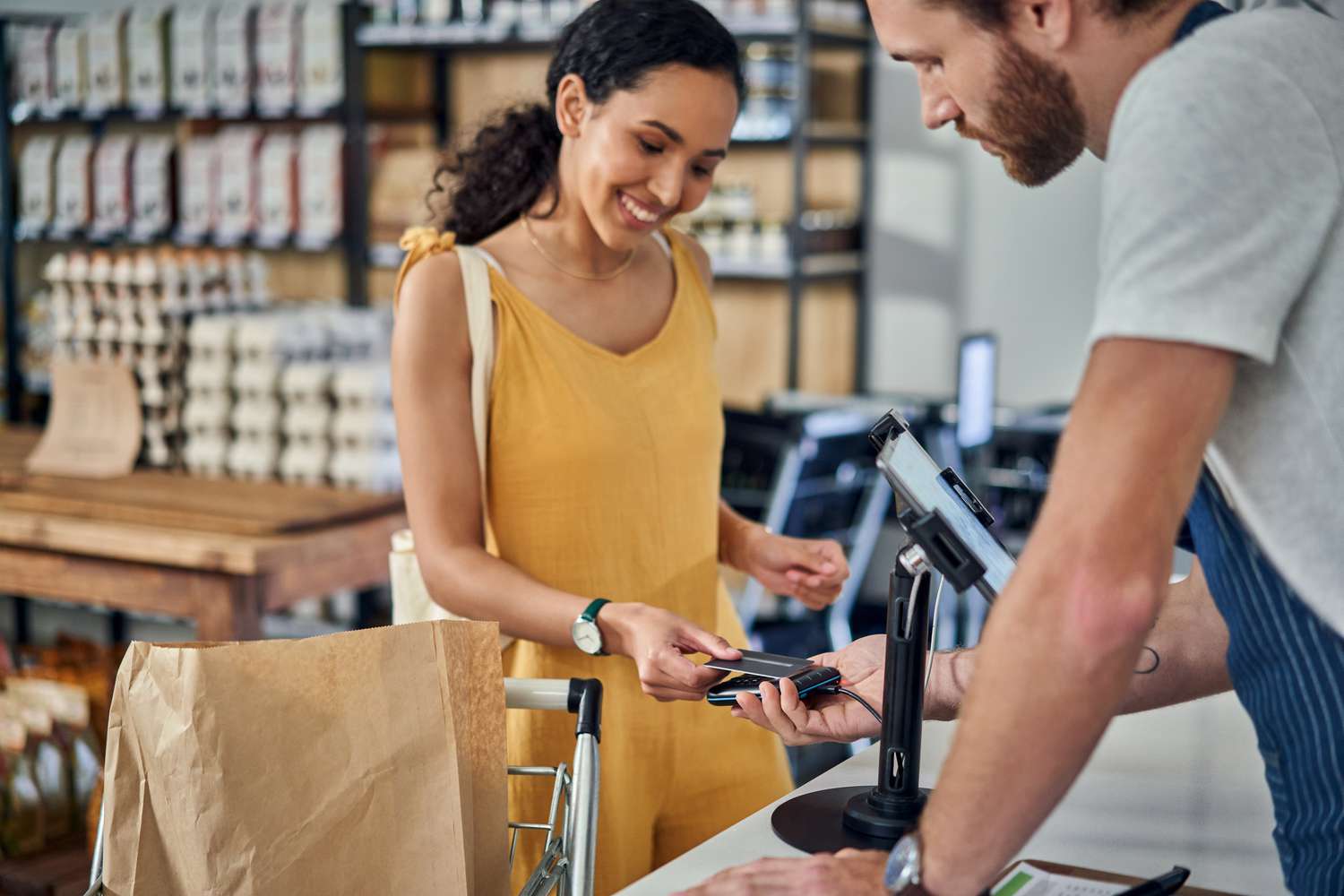 A woman makes a credit card purchase at a store.