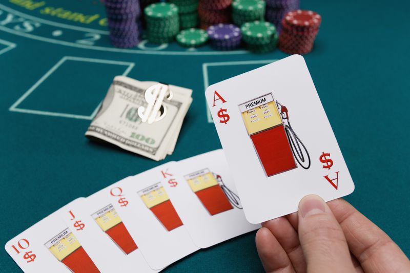 Playing cards with gas premiums around hundred dollar bills