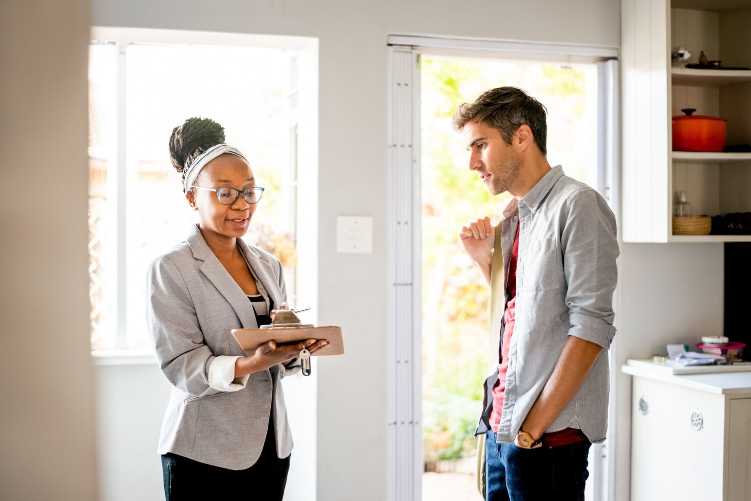 Landlord holding a clipboard looking at documents with a tenant