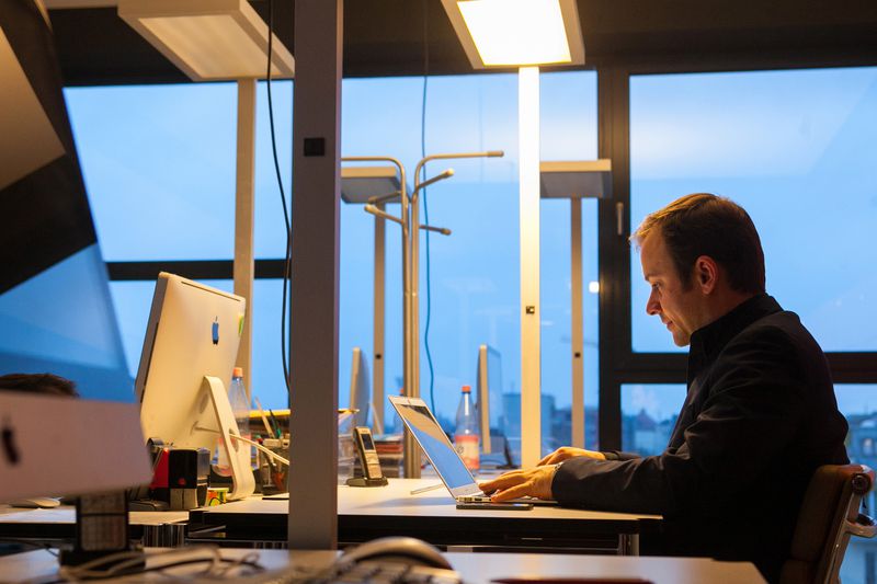 Man sitting in an office working on a laptop
