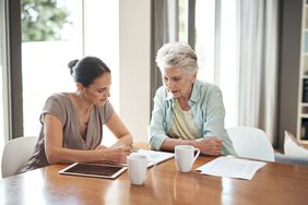 Mother and daughter sitting at a table looking at documents