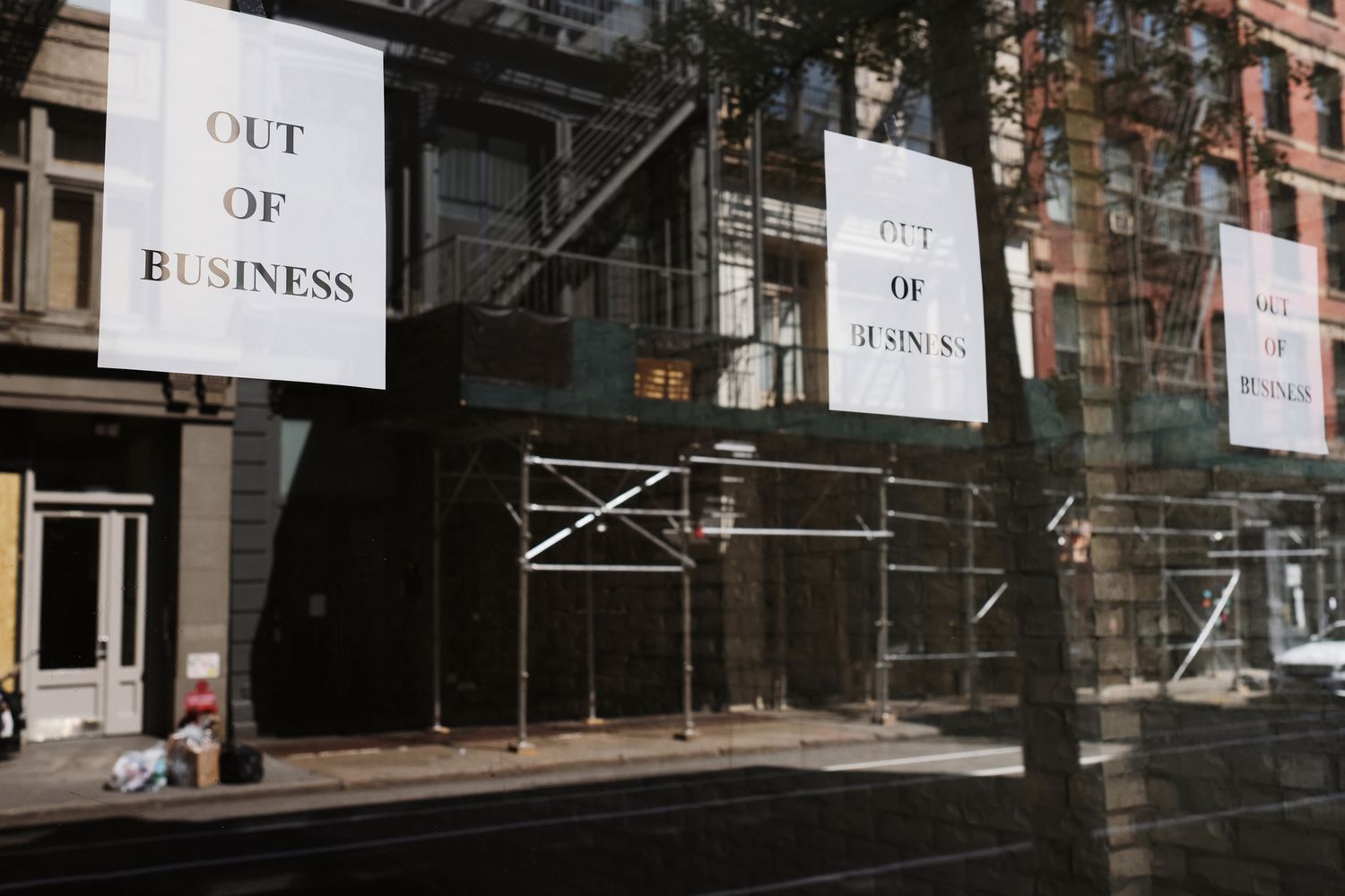 The window with going out of business signs that reflect a depressed area of a town during an economic slump.