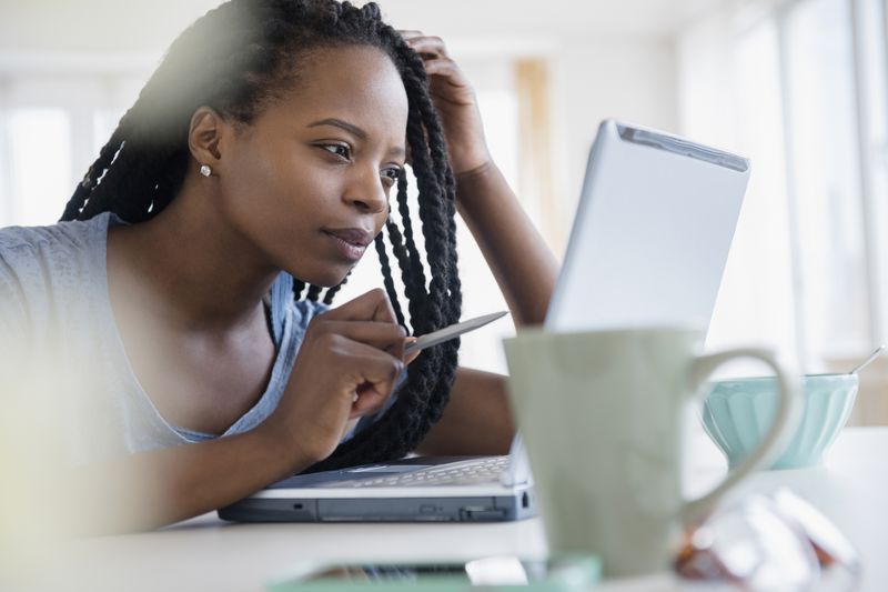 A woman studies information on a laptop.