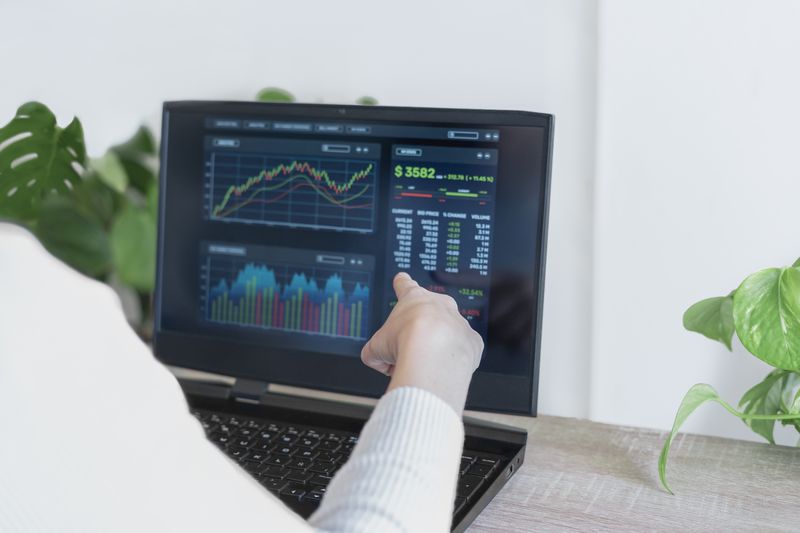 Woman pointing to data on a monitor.