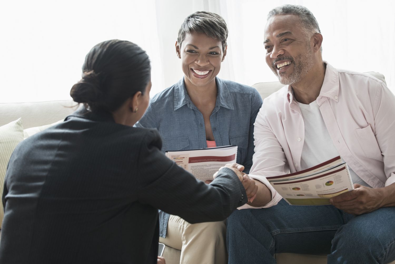 Middle-aged African American couple discussing retirement plans with financial advisor.