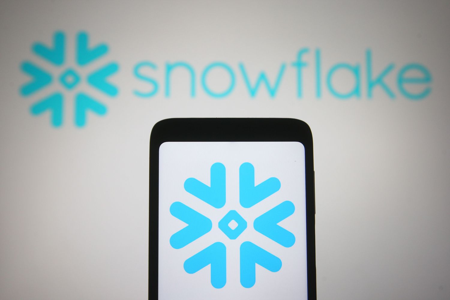 Snowflake logo on a smartphone and PC screen
