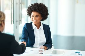 Two people shaking hands in an office.