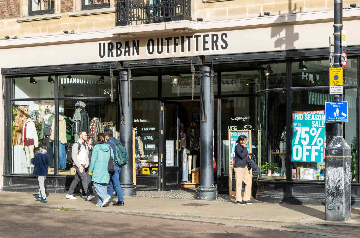 People walk outside the front of an Urban Outfitters location.