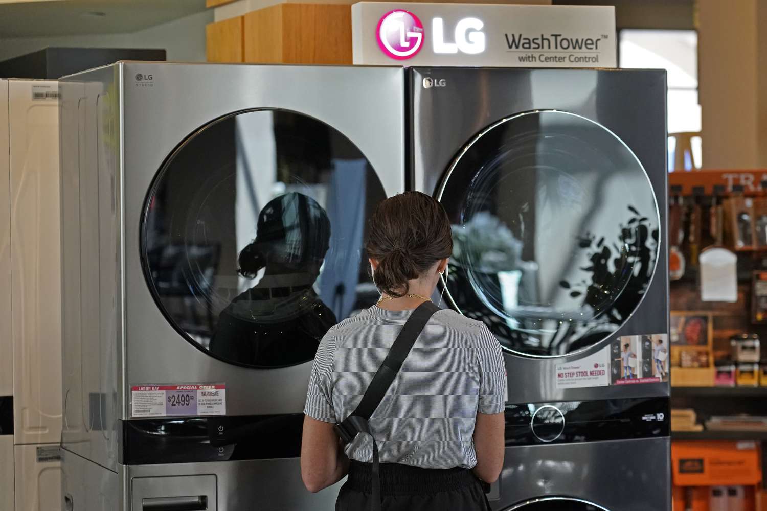 A shopper stands near a washer-dryer set. 