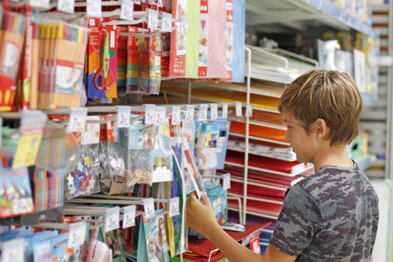 Boy looking at school supplies at a stationery store. 