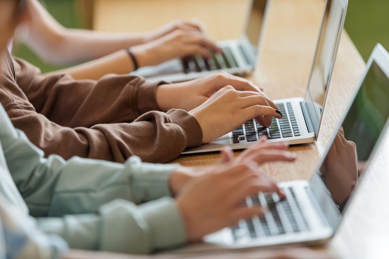Three people typing on laptops