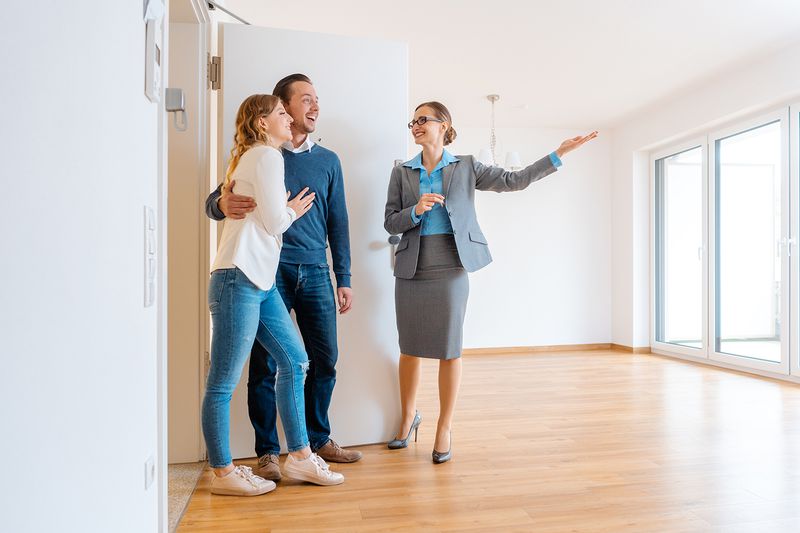 Real Estate Agent showing house to a young couple from a rental listing site