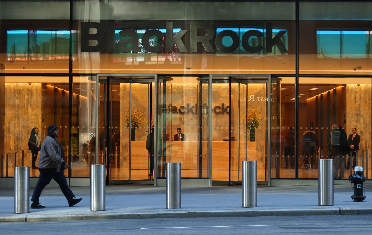 A person walks by the front entrance of the headquarters for the investment management firm BlackRock