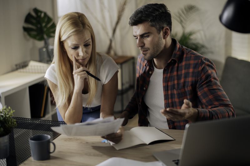 A couple sitting at home trying to understand their mortgage options and different ways to obtain it.