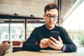  businessman looking at CD account with mobile application